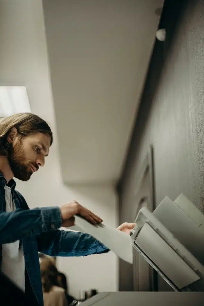 Man in Blue Denim Jacket Holding a Printing Paper