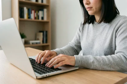 Femme utilisant un MacBook Pro pour taper un raccourci clavier dans un bureau à domicile moderne